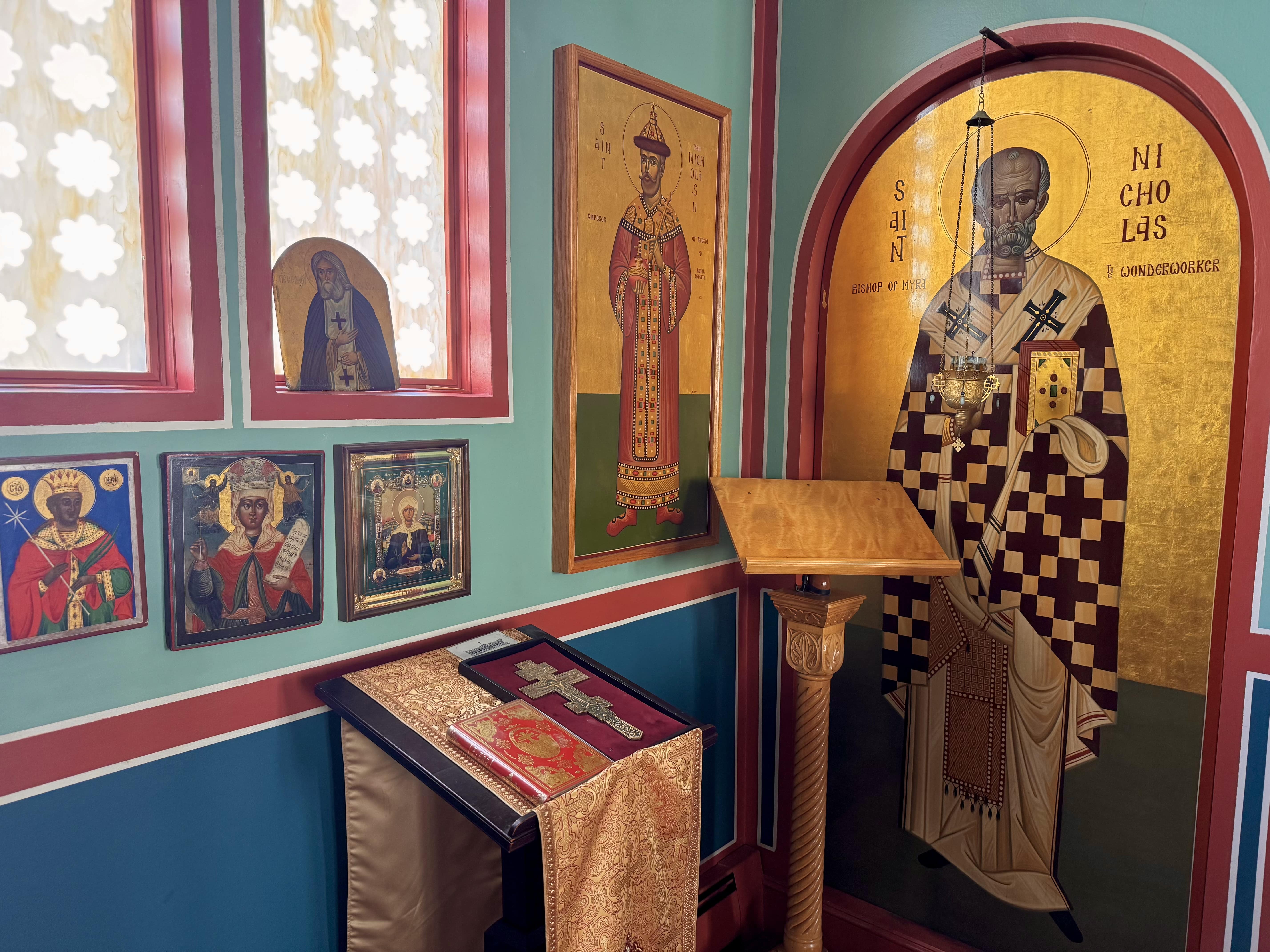The Cross and the Gospel on a stand next to the icon of St. Nicholas